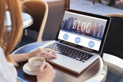 Woman Reading Blog Content on Laptop